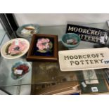 A MOORCROFT POTTERY OBLONG DISH, A DISPLAY WITH FRUIT DECORATION, A FRAMED POT LID, AND FOUR PIN