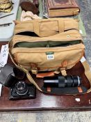 AN OLYMPUS OM-1 CAMERA, CARRYING BAG WITH ACCESSORIES AND LENSES TO INCLUDE A ZUIKO MC AUTO-ZOOM