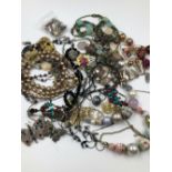 A COLLECTION OF COSTUME JEWELLERY TO INCLUDE EARRINGS, BEADS, CHAINS, CERAMIC FLORAL BROOCH ETC.