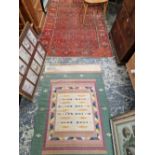 AN ANTIQUE HAND WOVEN PERSIAN RUG AND A LATER FLAT WEAVE MAT