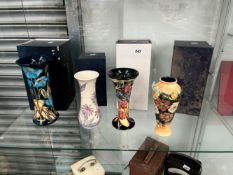 FOUR MOORCROFT VASES IN DIFFERENT DESIGNS SIGNED PHILIP GIBSON, WM, AND TWO FOR E.BOSSONS.