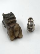 AN ORIENTAL 970 GRADE SILVER BUST CHARM TOGETHER WITH A CARVED HARDSTONEFOOP DOG. SILVER WEIGHT