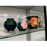 A ROSE DECORATED MOORCROFT JUG, A TRI TONE VASE AND A PLANTER.