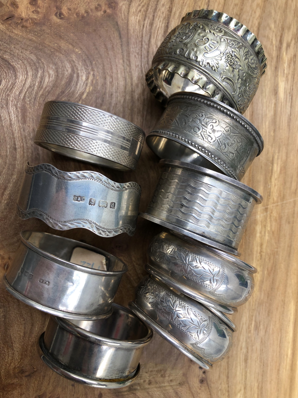 EIGHT VARIOUS HALLMARKED SILVER NAPKIN RINGS TOGETHER WITH A PLATED EXAMPLE. GROSS SILVER WEIGHT
