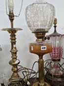 A CRANBERRY GLASS OVERLAY TABLE LAMP, A BRASS TABLE LAMP AND AN OIL LAMP