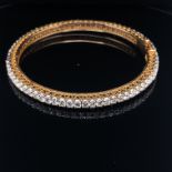 A DIAMOND HINGED BANGLE WITH TWO FIGURE OF EIGHT SAFETY CLASPS, SET WITH 70 ROUND BRILLIANT CUT