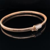 A ROSE GOLD AND DIAMOND SET FLEXIBLE SPRUNG BANGLE WITH INTEGRATED CLASP AND A FIGURE OF EIGHT