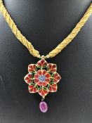AN INDIAN KUNDAN VINTAGE POLKI PENDANT. THE FRONT SET WITH VARIOUS GEMSTONES TO INCLUDE RUBY,