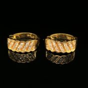 A PAIR OF DIAMOND SET HUGGIE HOOPS. THE BACK HINGED STAMPED 750, ASSESSED AS 18ct GOLD. 33