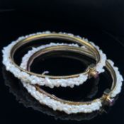A PAIR OF FRESHWATER PEARL SPRUNG BANGLES. THE MULTI PEARL DESIGN WOVEN INTO THE REVERSE OF THE