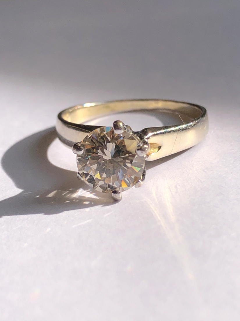 A DIAMOND SINGLE STONE RING. THE ROUND BRILLIANT DIAMOND IN A SIX CLAW RAISED SETTING UPON A PLAIN - Image 11 of 11