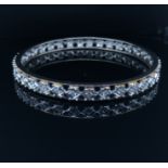 A DIAMOND SET CONTINUOUS BANGLE. THE BANGLE UNMARKED, ASSESSED AS NICKEL SILVER. ESTIMATED OVERALL