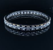 A DIAMOND SET CONTINUOUS BANGLE. THE BANGLE UNMARKED, ASSESSED AS NICKEL SILVER. ESTIMATED OVERALL