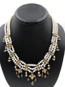 A TRADITIONAL TRIPLE ROW PEARL AND GEMSET NECKLACE. THE PEARLS STRUNG TO MEET GEMSET KUNDAN