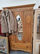 A PINE WARDROBE WITH AN OVAL MIRRORED DOOR OVER A DRAWER. W 109 x D 46 x H 193cms.