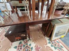 A 19th C. MAHOGANY DROP FLAP TABLE ON TURNED CYLINDRICAL LEGS TAPERING TO BRASS CASTER FEET