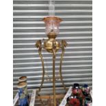 A FLOOR STANDING OIL LAMP, THE BRASS RECEIVER CRADLED BETWEEN THREE DRAGONS HEADS AT THE TOP OF