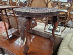 A BURMESE CARVED HARDWOOD CENTRE TABLE WITH ELEPHANT SUPPORTS
