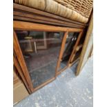 A LINEN BASKET FILLED WITH CUSHIONS AND TOGETHER WITH A GLAZED PINE WALL CUPBOARD. W 71 x D 29 x H