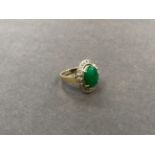 A JADE AND DIAMOND CLUSTER RING. THE JADE CABOCHON MEASURING 12.2 X 9.8 X D 2.9mm, APPROXIMATE