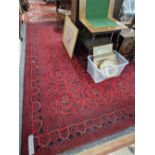 A HAND WOVEN RED GROUND EASTERN CARPET.