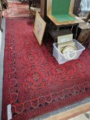 A HAND WOVEN RED GROUND EASTERN CARPET.
