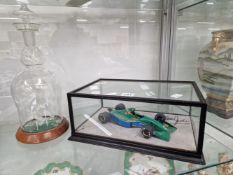 A CASED FORMULA 1 RACING CAR SIGNED BY EDDIE JORDAN TOGETHER WITH A DECANTER CONTAINING A FROSTED