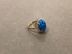 AN OPAL AND DIAMOND CLUSTER RING. UNHALLMARKED, STAMPED 375, ASSESSED AS 9ct GOLD. WEIGHT 3.53grms.