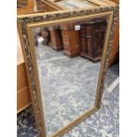 A RECTANGULAR BEVELLED GLASS MIRROR IN A GILT FRAME. 98 x 66cms.