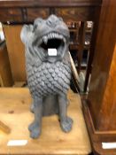 A BLACK PAINTED TERRACOTTA SEATED LION ROARING. H 62cms.