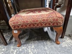 A FOOTSTOOL WITH ELEPHANT DEPICTED SEAT ABOVE CABRIOLE LEGS ON PAD FEET.