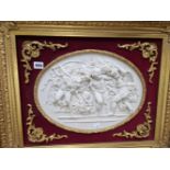 AN ANTIQUE STYLE RELIEF PANEL DEPICTING PUTTI WITHIN A GILDED FRAME