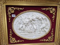 AN ANTIQUE STYLE RELIEF PANEL DEPICTING PUTTI WITHIN A GILDED FRAME