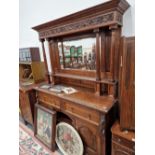 A VICTORIAN OAK MIRROR BACKED SIDEBOARD WITH CARVED FRUIT AND VINE DECORATION