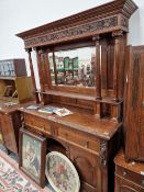 A VICTORIAN OAK MIRROR BACKED SIDEBOARD WITH CARVED FRUIT AND VINE DECORATION