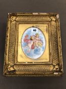 AN ANTIQUE GILT FRAMED HAND PAINTED PORCELAIN PLAQUE DECORATED WITH CHERUBS.