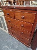 A VICTORIAN MAHOGANY CHEST OF DRAWERS WITH BUN HANDLES.