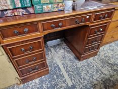 A 20th C. MAHOGANY PEDESTAL DESK WITH RED LEATHER INSET TOP OVER A KNEEHOLE DRAWER FLANKED BY