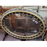 A LARGE MODERN OVAL MIRROR.