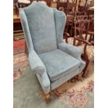 A GEORGIAN STYLE WING BACK ARM CHAIR.