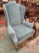 A GEORGIAN STYLE WING BACK ARM CHAIR.