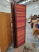 A MAHOGANY FIVE FOLD SCREEN, THE TEXTILE PANELS STRIPED IN PINKS AND ORANGE