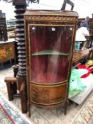 A FRENCH OAK AND BRASS MOUNTED BOW FRONT CORNER CABINET.
