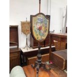 A VICTORIAN ROSEWOOD POLE SCREEN, THE SHIELD SHAPED FRAMED NEEDLE WORK BANNER WORKED WITHA VASE OF