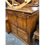 A GEORGIAN STYLE OAK TV CABINET.