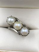 A VINTAGE THREE STONE PEARL RING, THE SHANK STAMPED 9ct, ASSESSED AS 9ct WHITE GOLD, LARGEST PEARL