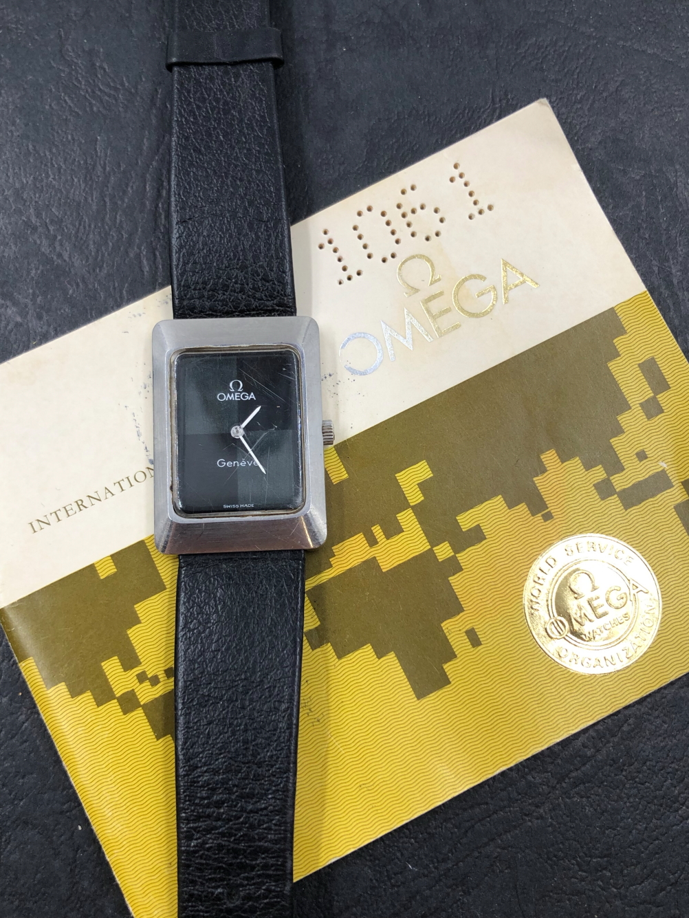 AN OMEGA GENEVE MANUAL WOUND WRIST WATCH, AND A GUARANTEE BOOKLET DATED 1978, REF 1061. WATCH WINDS,