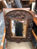 AN ANTIQUE CARVED OAK FRAMED WALL MIRROR