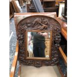 AN ANTIQUE CARVED OAK FRAMED WALL MIRROR