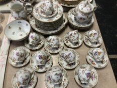 A GERMAN PORCELAIN PART TEA SET PAINTED WITH FLOWERS AMONGST GILDING